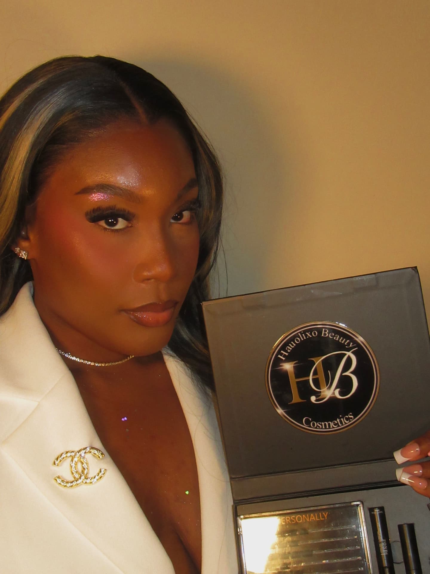 Founder of Hauolixo Beauty Cosmetics holding an open Hauolixo Beauty lash kit